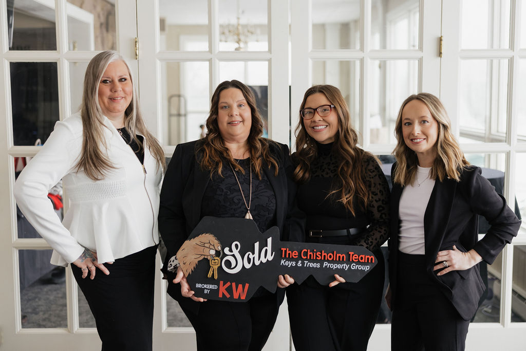 The Chisholm Team holding a sold sign